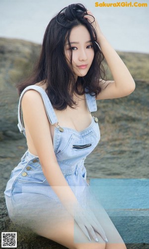 A woman in a white towel standing in the ocean.