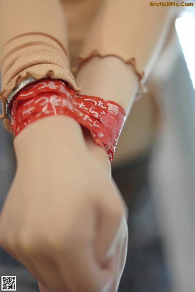 A close up of a person wearing a red bandana on their wrist.