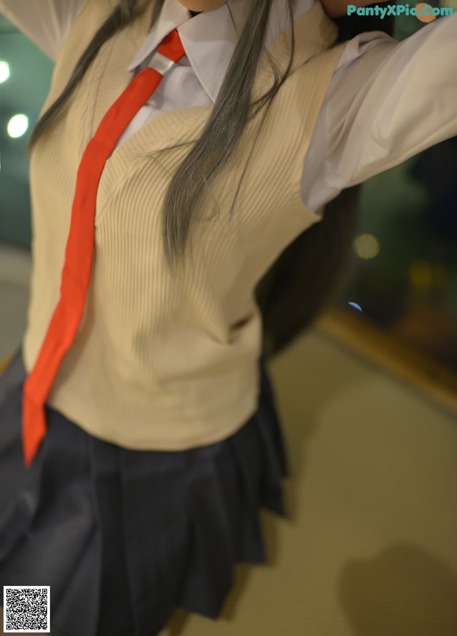 A woman in a school uniform with a red tie.