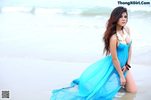 A woman in a blue bikini posing for a picture.