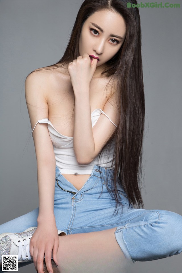 A woman sitting on top of a wooden stool.
