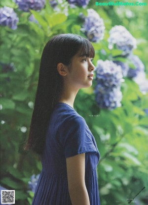 A young woman with long black hair and a blue dress.