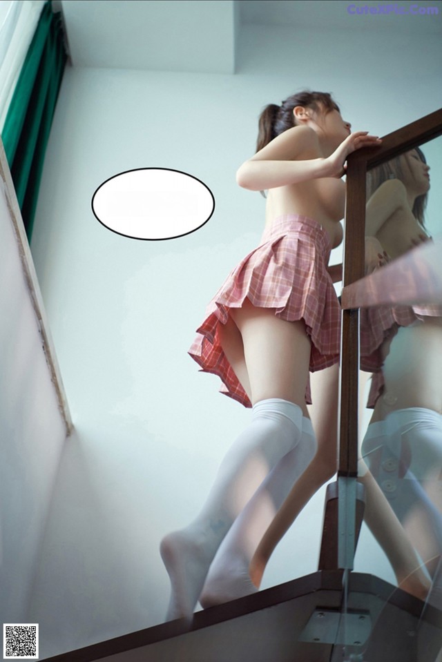 A woman in a skirt and stockings standing on a stairwell.