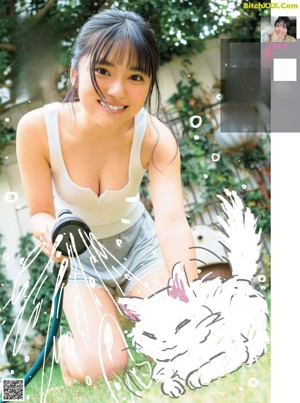 A woman is washing her cat with a hose.