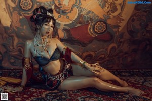 A woman laying on a rug in front of a painting.