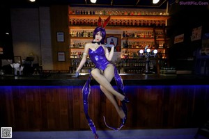 A woman in a bunny costume sitting at a bar.