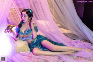 A woman in a blue lingerie sitting on a bed.