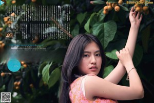 A woman standing in front of an orange tree.