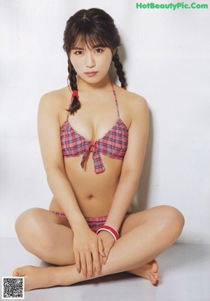 A woman in a black and white bathing suit sitting on a chair.