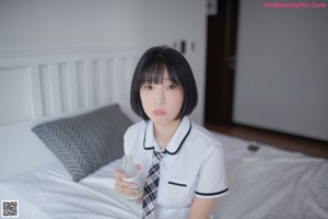 A woman in a school uniform is putting on lipstick.