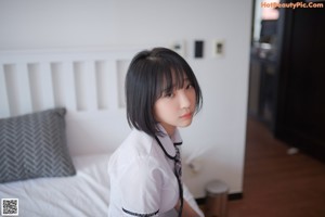 A woman in a school uniform is posing for a picture.
