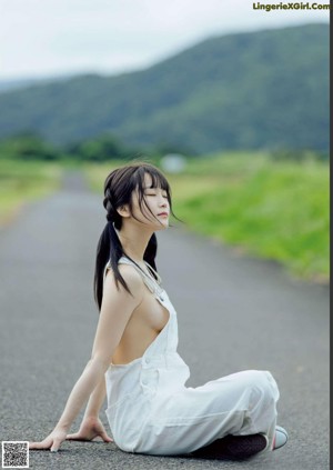 A woman in a white dress posing on a bed.