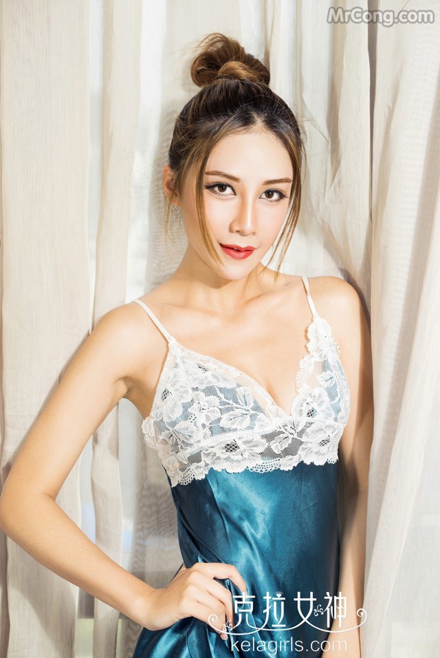 A woman in a blue dress posing for a picture.