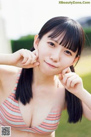 A woman in a striped bikini posing for a magazine.