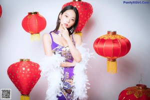 A woman in a purple dress posing for a picture.