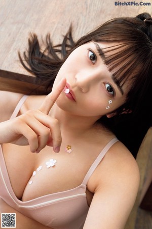 A woman in a pink shirt and blue panties posing for a picture.