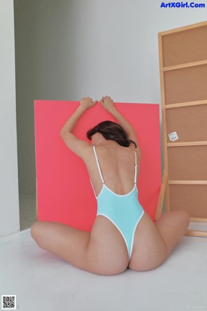 A woman in a blue and white bathing suit standing in a room.