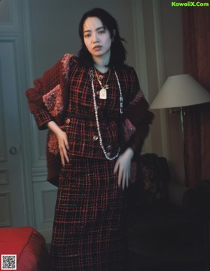 A woman standing in a room next to a bed.