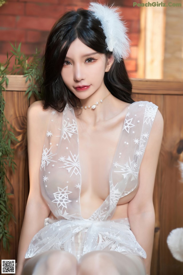 A woman in a white lingerie sitting on a wooden bench.