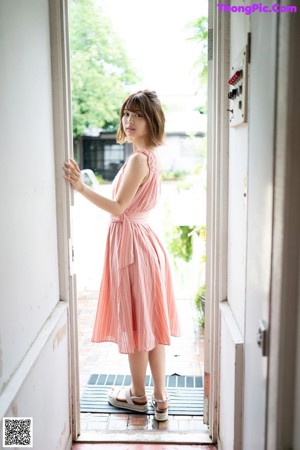 A woman in a white robe is posing for a picture.