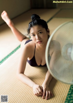 A woman in a red and white bikini sitting on the floor.