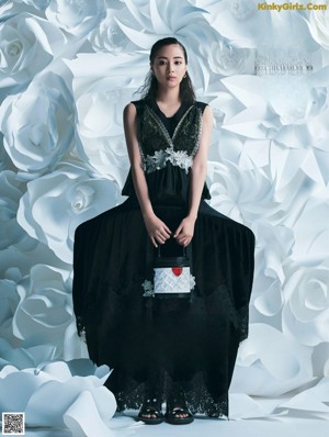 A woman in a white jacket and black shorts posing for a magazine.
